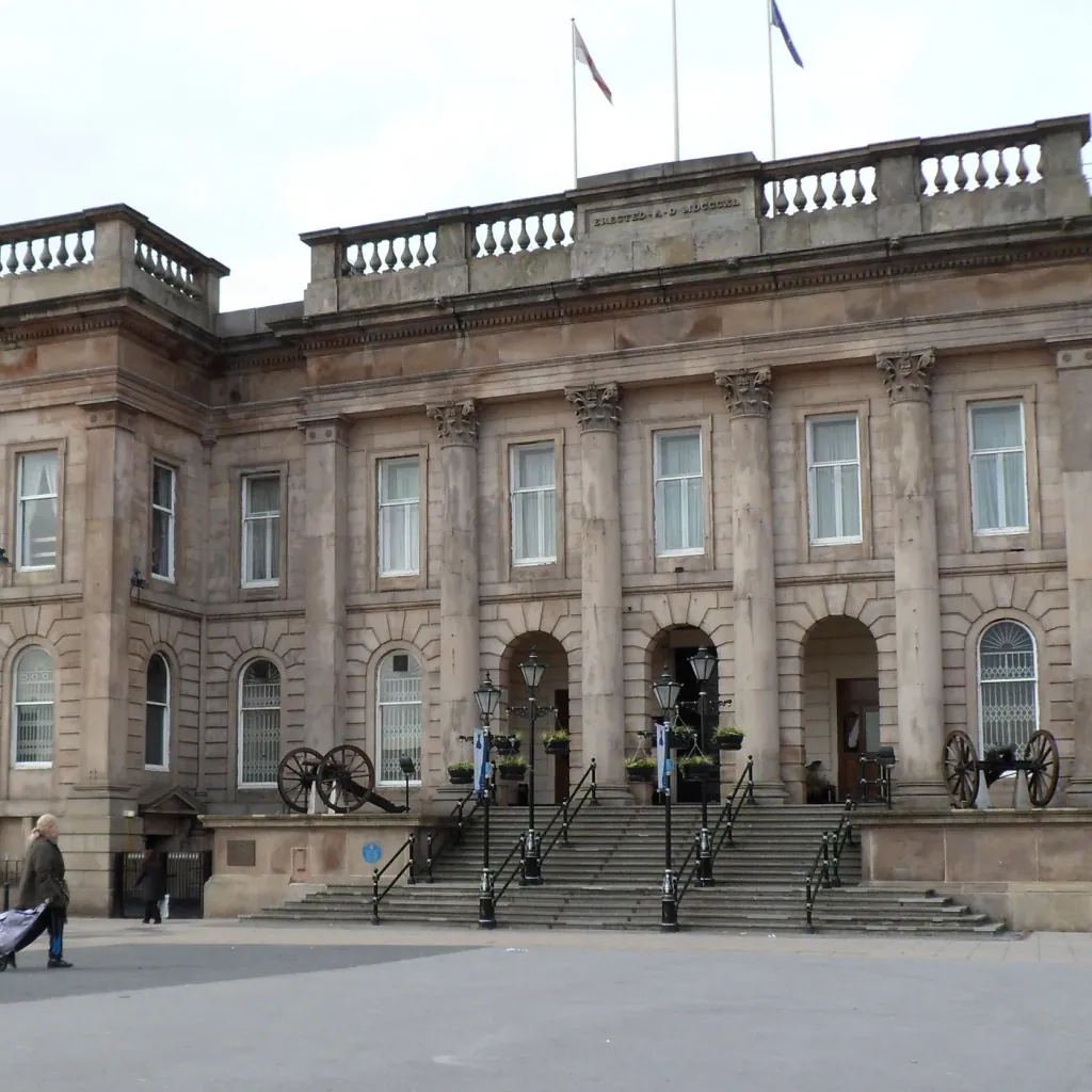 The stone front of Ashton Town Hall on Market Place in Ashton-under-Lyne, with its steps and two cannons