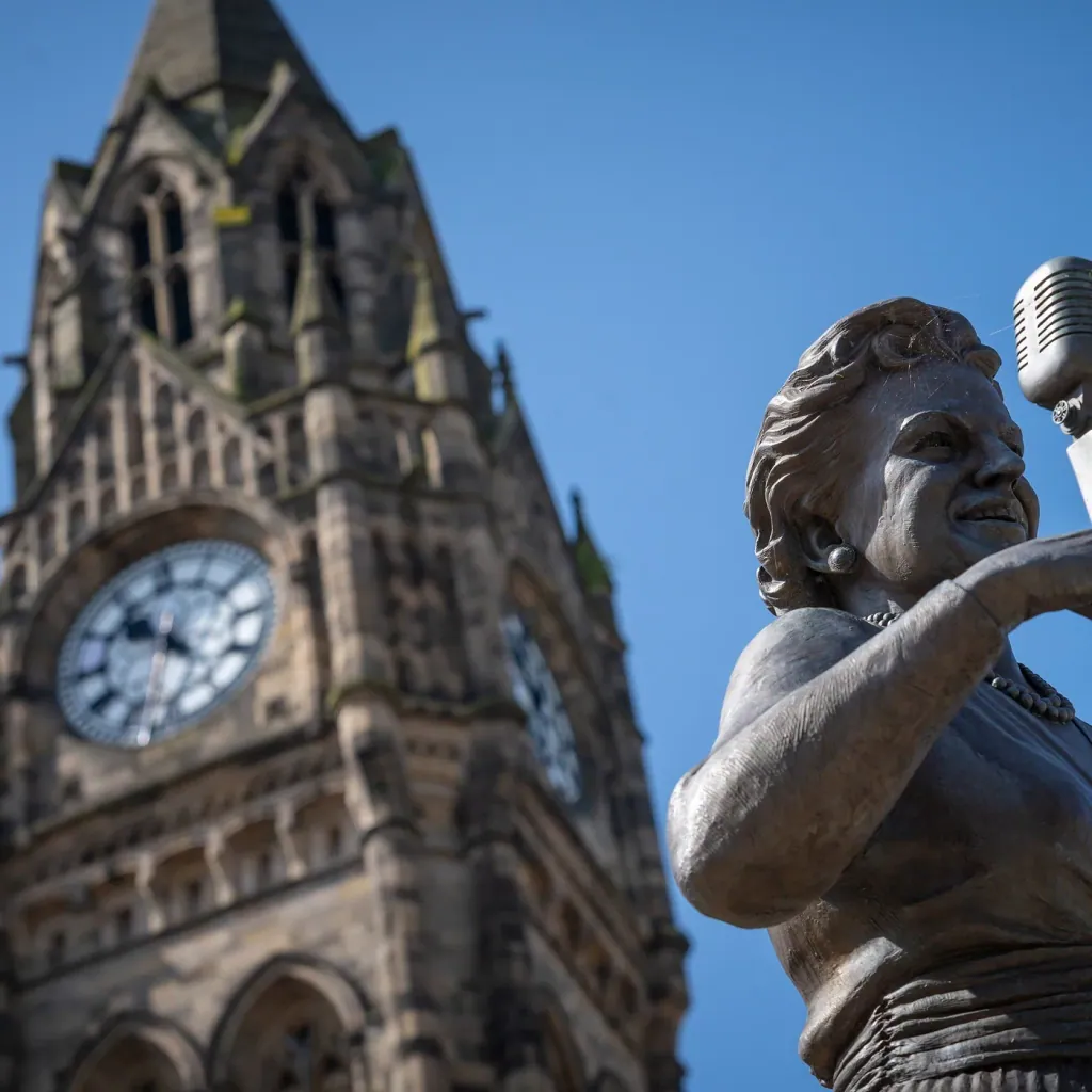 The Gracie Fields statue in front of the clock tower of Rochdale Town Hall
